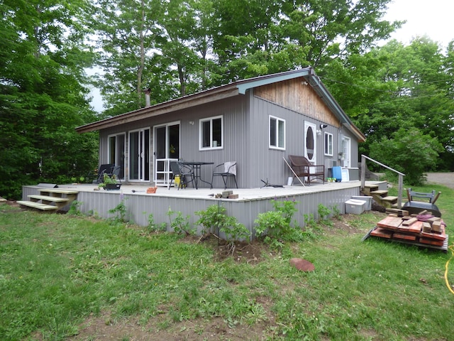 rear view of property with a lawn and a wooden deck