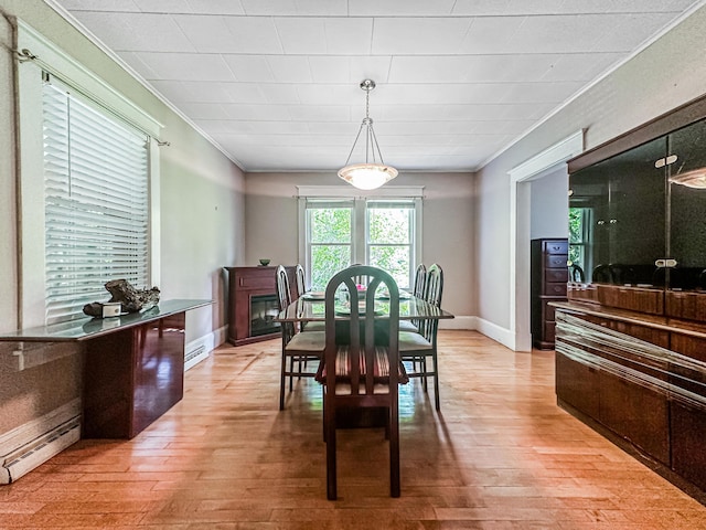 dining room featuring baseboard heating, light hardwood / wood-style floors, and ornamental molding