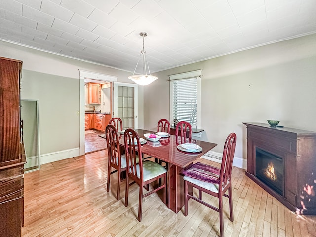 dining room with light hardwood / wood-style floors and ornamental molding