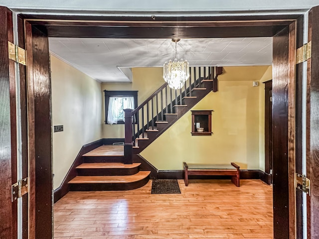 staircase featuring wood-type flooring and an inviting chandelier