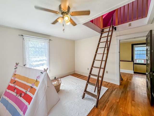 bedroom with multiple windows, hardwood / wood-style floors, and ceiling fan