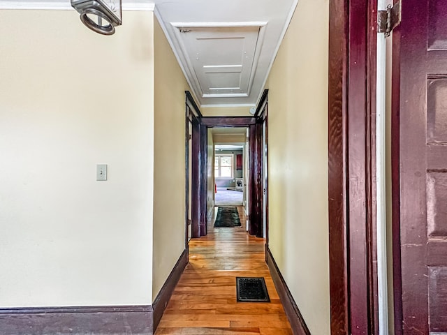 hall with hardwood / wood-style floors and ornamental molding