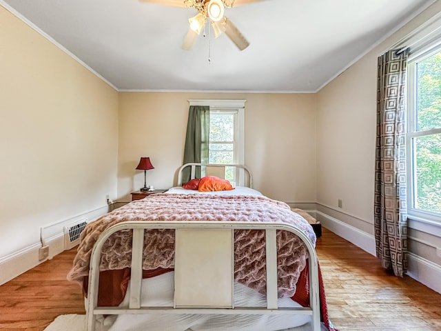 bedroom with ceiling fan, crown molding, and light wood-type flooring