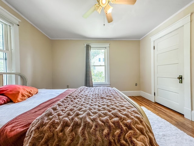 bedroom featuring ceiling fan, light hardwood / wood-style flooring, and crown molding