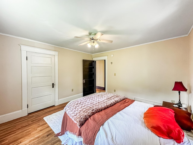 bedroom featuring ceiling fan, crown molding, and light hardwood / wood-style floors