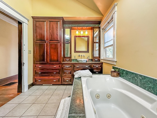 bathroom featuring tile patterned floors, vanity, a tub to relax in, and vaulted ceiling