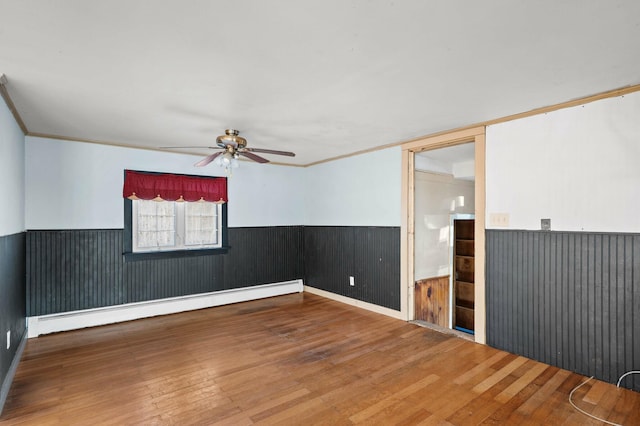 192 Fox Hill Rd, Athens, ME 04912 - unfurnished room featuring wainscoting, a baseboard radiator, ceiling fan, wood finished floors, and crown molding