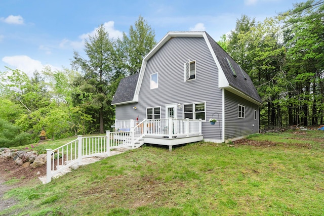 back of house featuring a lawn and a deck