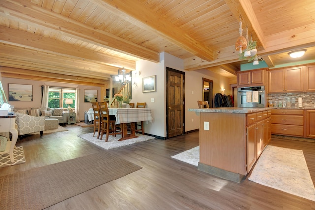 kitchen featuring pendant lighting, wood ceiling, beam ceiling, and stainless steel oven