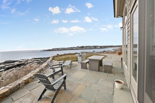 view of patio / terrace featuring a water view and a fire pit