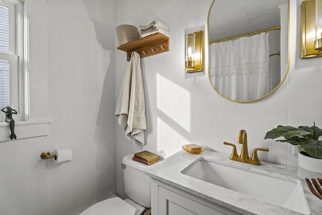 bathroom with vanity, toilet, and curtained shower