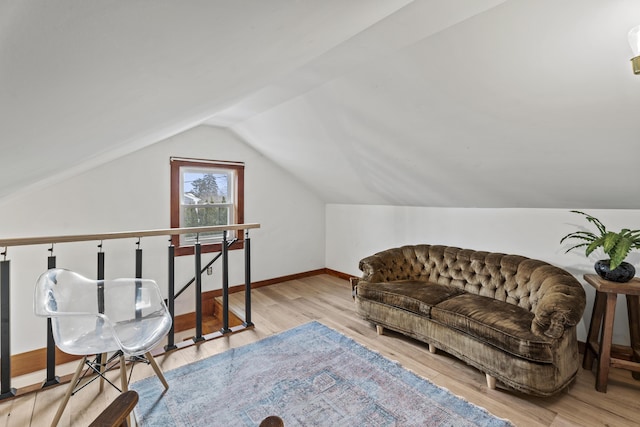 sitting room featuring light wood-type flooring and vaulted ceiling