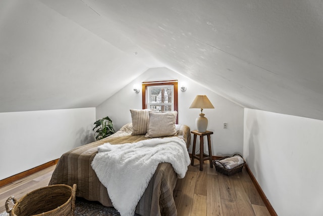 bedroom with hardwood / wood-style floors and vaulted ceiling