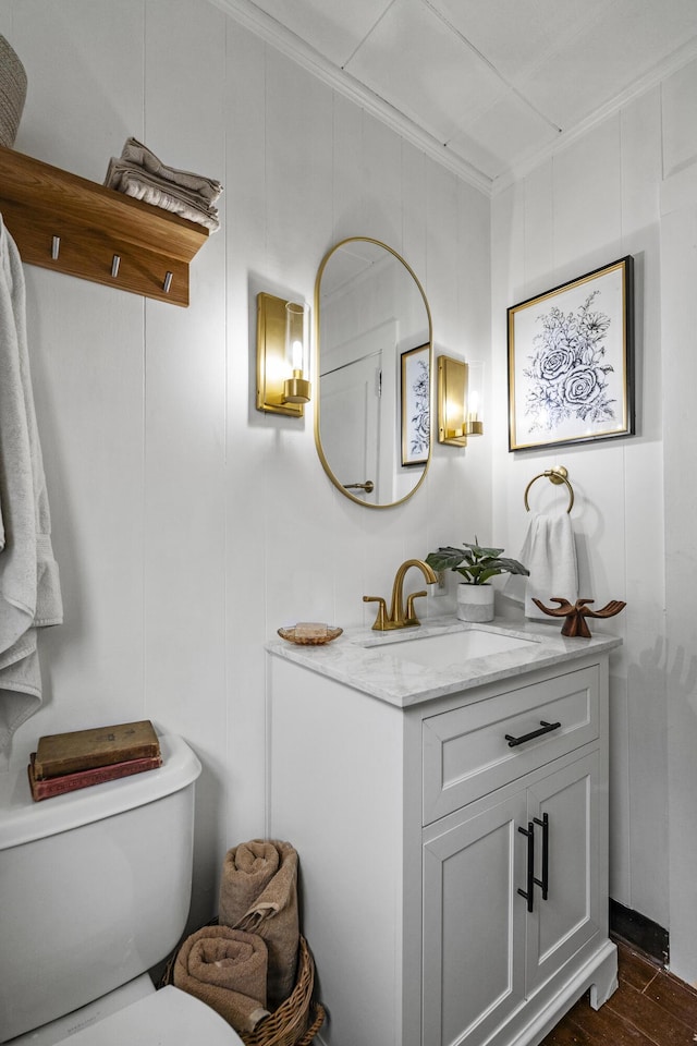 bathroom with hardwood / wood-style floors, vanity, toilet, and crown molding