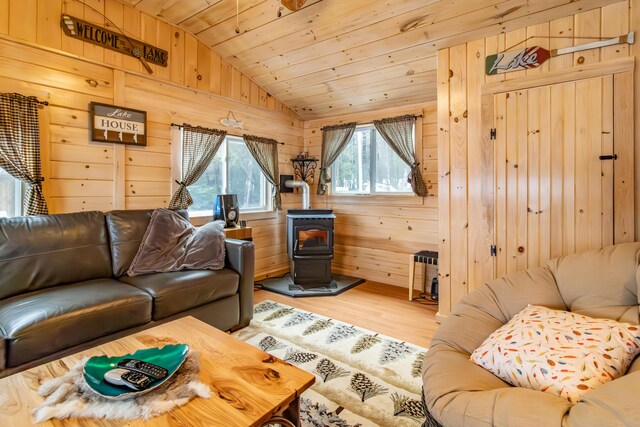380 Cedar Lake Rd Unit T3 R9, Nwp, ME 04462 - living room featuring vaulted ceiling, a wood stove, light wood-style floors, wooden walls, and wood ceiling