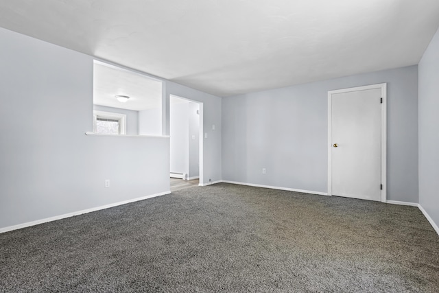 carpeted empty room featuring baseboard heating