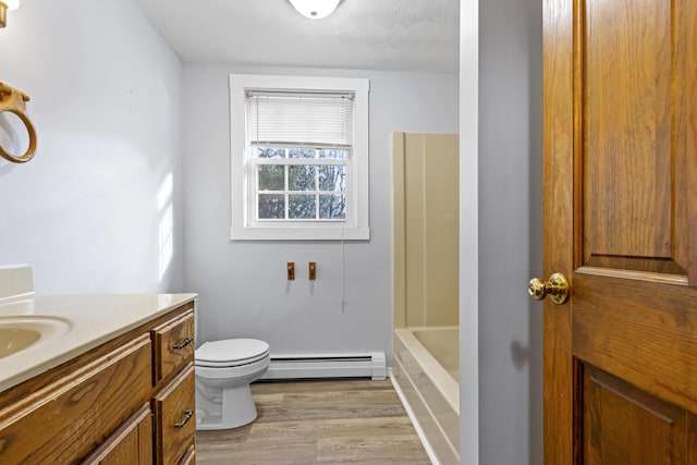 bathroom featuring vanity, toilet, wood-type flooring, and baseboard heating