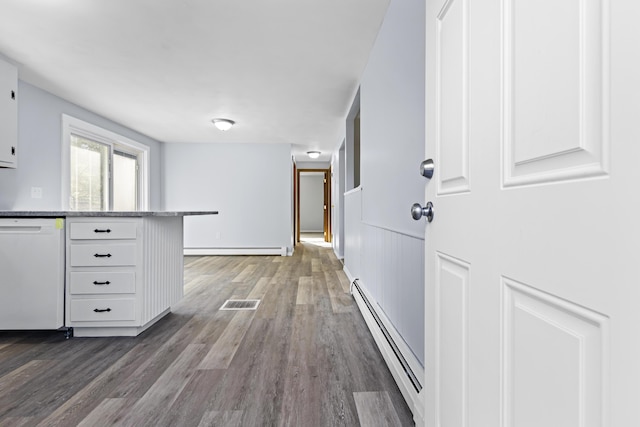 hallway with dark hardwood / wood-style floors and baseboard heating