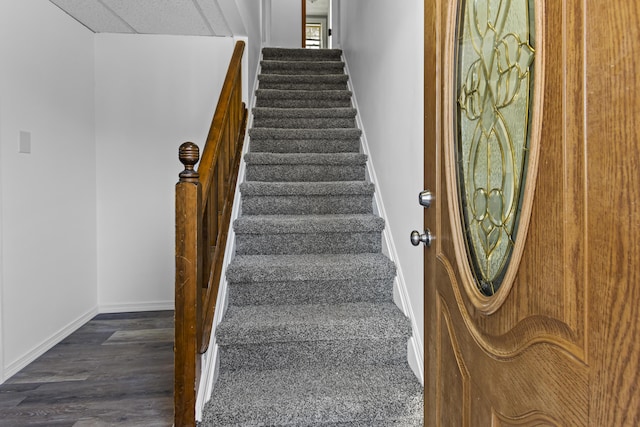 stairway featuring hardwood / wood-style floors and a drop ceiling