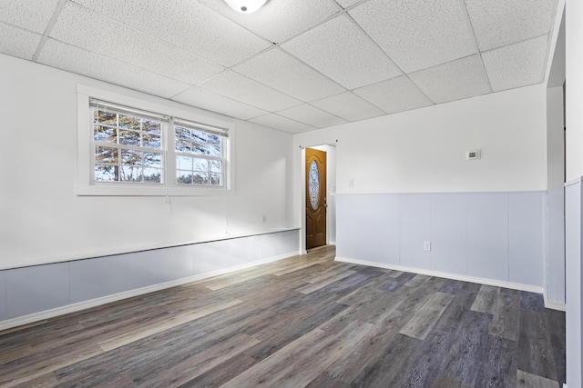 unfurnished room featuring a paneled ceiling and dark hardwood / wood-style floors