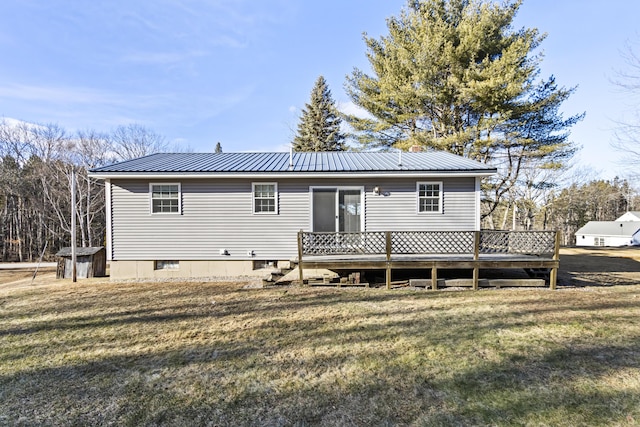 rear view of house featuring a lawn and a deck