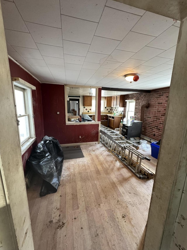 interior space with brick wall, wood-type flooring, and a wealth of natural light