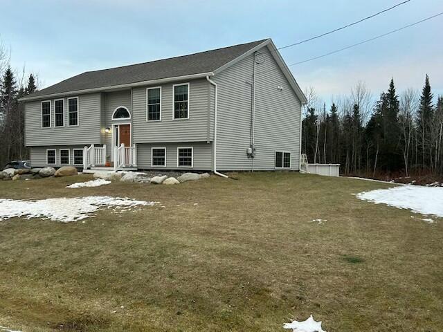 bi-level home featuring a front lawn