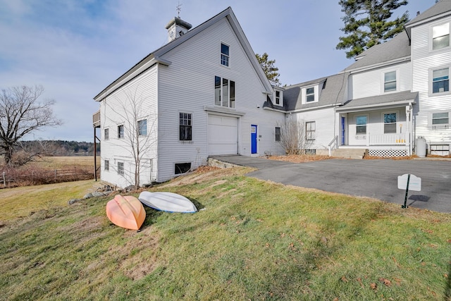 rear view of house with a lawn and a garage