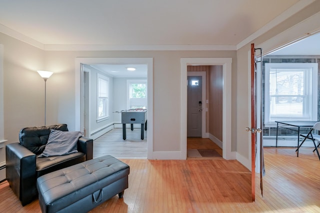 sitting room featuring crown molding, hardwood / wood-style floors, and a baseboard heating unit