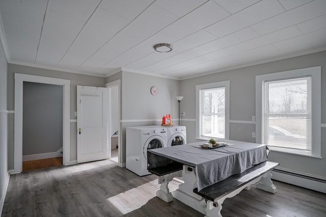 dining space featuring hardwood / wood-style floors, crown molding, washing machine and dryer, and baseboard heating