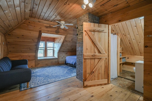 additional living space with wood ceiling, wooden walls, ceiling fan, and wood-type flooring