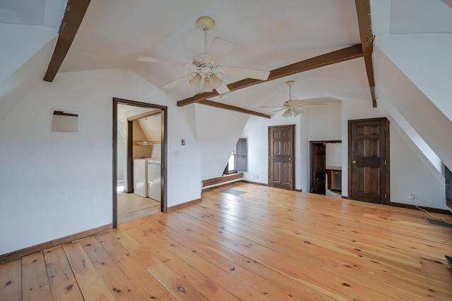 additional living space with washing machine and dryer, ceiling fan, light hardwood / wood-style floors, and vaulted ceiling