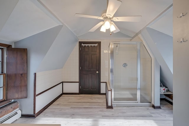 interior space featuring light hardwood / wood-style floors, baseboard heating, lofted ceiling, and ceiling fan