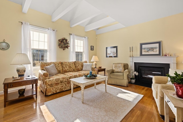 living room featuring beamed ceiling and light hardwood / wood-style floors