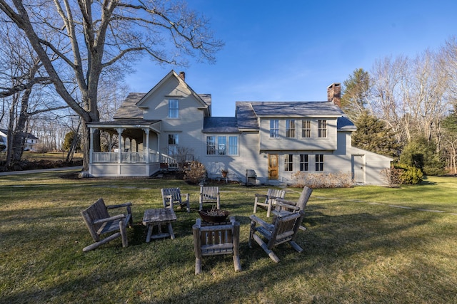 back of property featuring covered porch and a yard