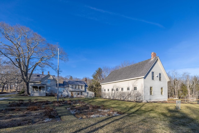 rear view of property featuring a lawn