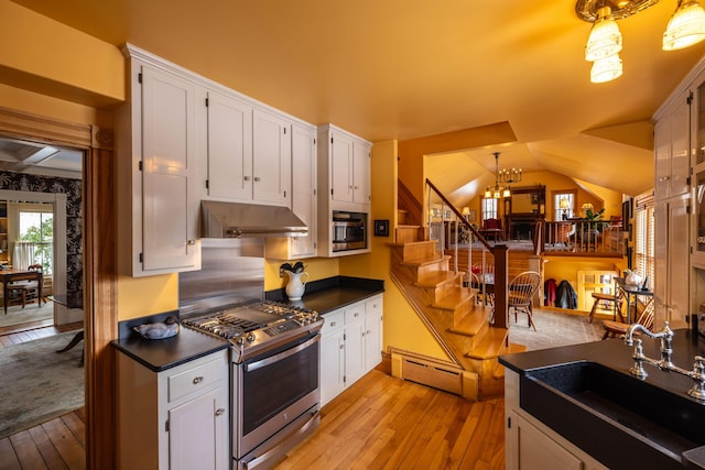 kitchen with pendant lighting, sink, stainless steel gas stove, a baseboard radiator, and white cabinetry