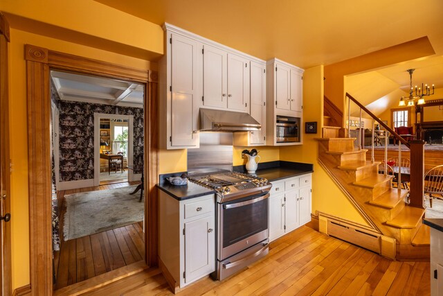 kitchen with appliances with stainless steel finishes, a baseboard radiator, an inviting chandelier, light hardwood / wood-style floors, and white cabinetry