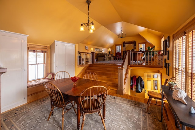 dining area featuring dark hardwood / wood-style flooring, lofted ceiling, and an inviting chandelier