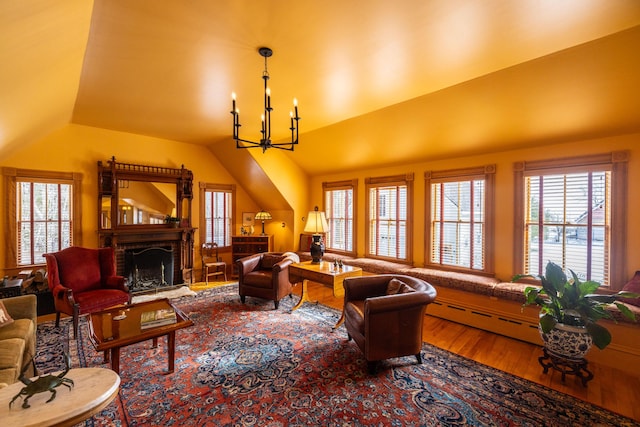 living room featuring a chandelier, wood-type flooring, baseboard heating, and vaulted ceiling