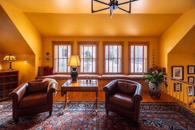 living room with ceiling fan, wood-type flooring, and lofted ceiling