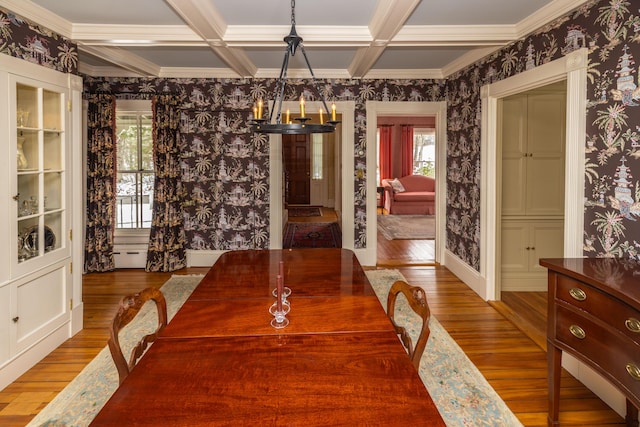 dining space with a chandelier, beam ceiling, hardwood / wood-style flooring, and crown molding