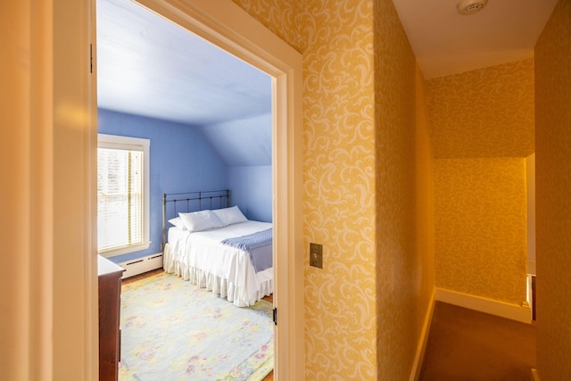 bedroom featuring lofted ceiling and a baseboard heating unit