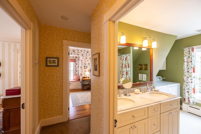 bathroom featuring independent washer and dryer, vanity, and a baseboard heating unit