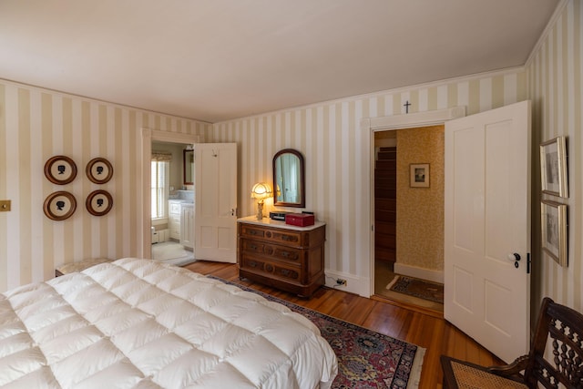 bedroom featuring ensuite bathroom, ornamental molding, and light wood-type flooring