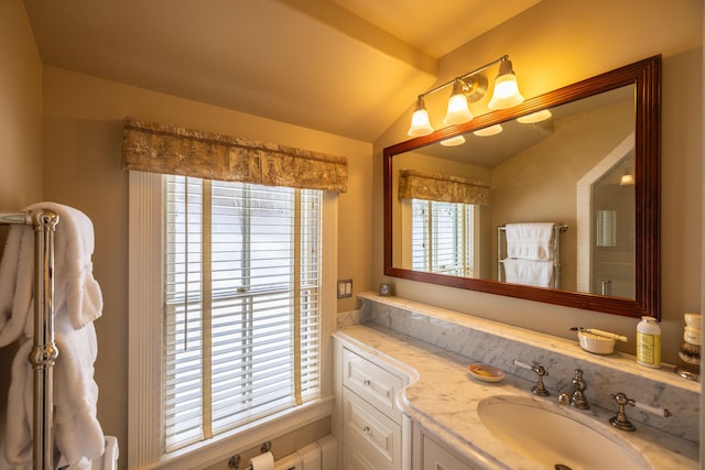 bathroom with plenty of natural light, vanity, and vaulted ceiling