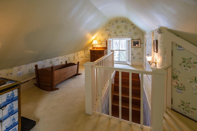 additional living space featuring light colored carpet and vaulted ceiling