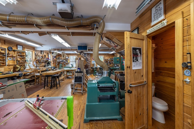 misc room featuring a workshop area, wood walls, and hardwood / wood-style flooring