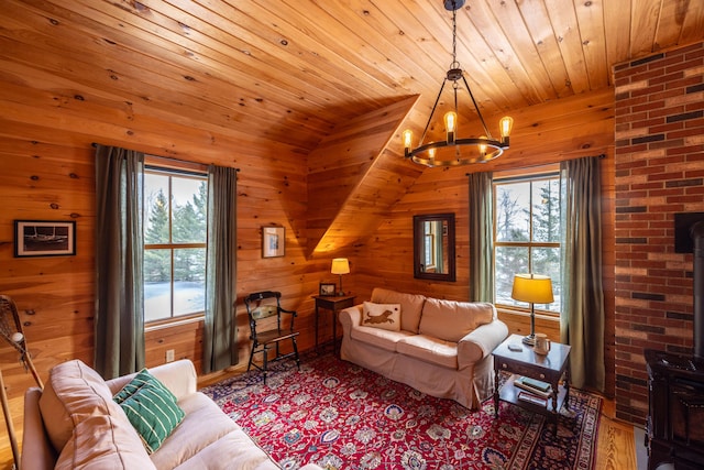 living room featuring a chandelier, vaulted ceiling, a wood stove, and wooden ceiling