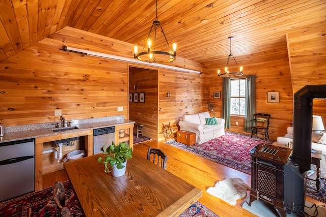 dining space with vaulted ceiling, light hardwood / wood-style flooring, an inviting chandelier, and wood ceiling